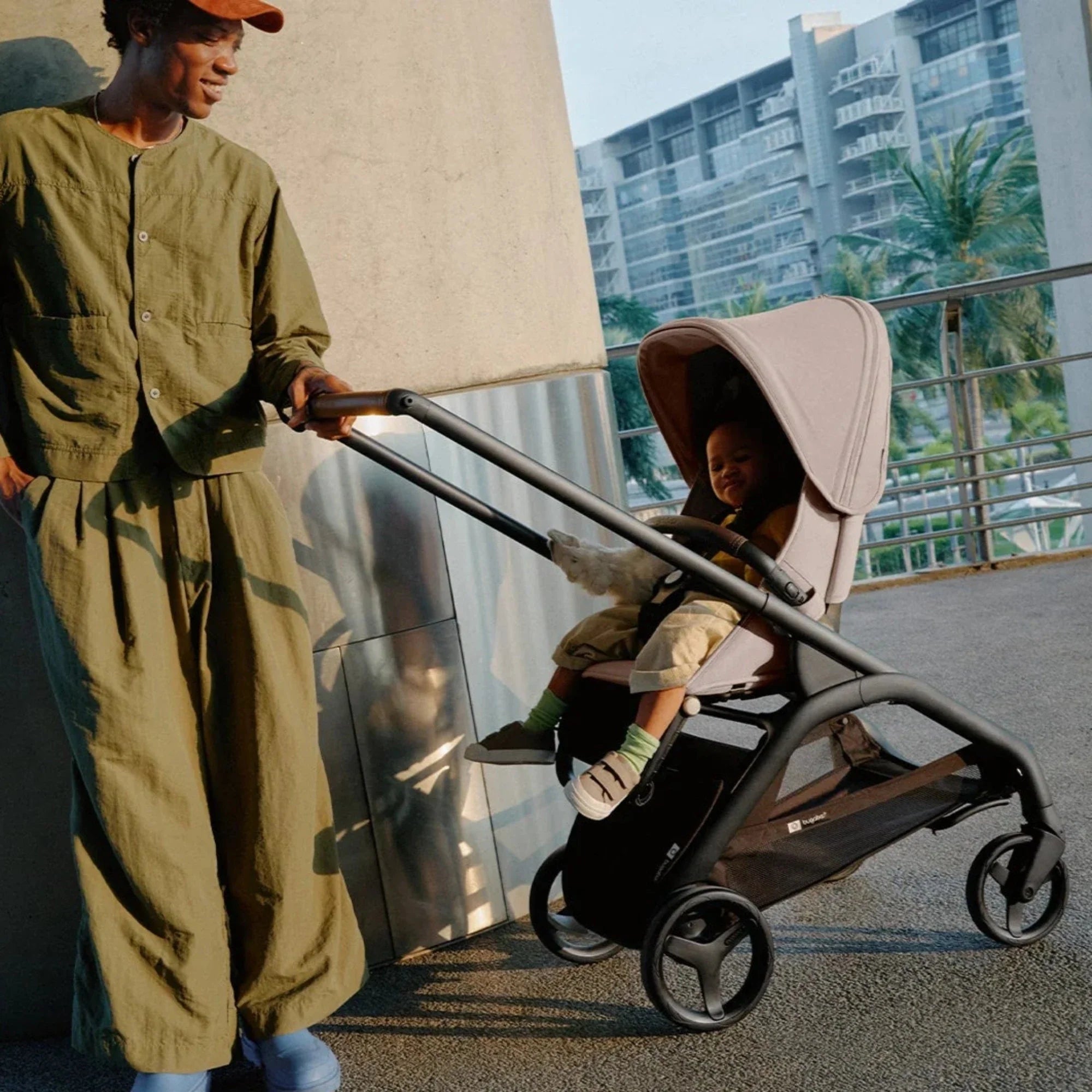 Bugaboo Dragonfly stroller with baby seated comfortably and father standing beside, enjoying a smooth, stylish everyday stroll.  