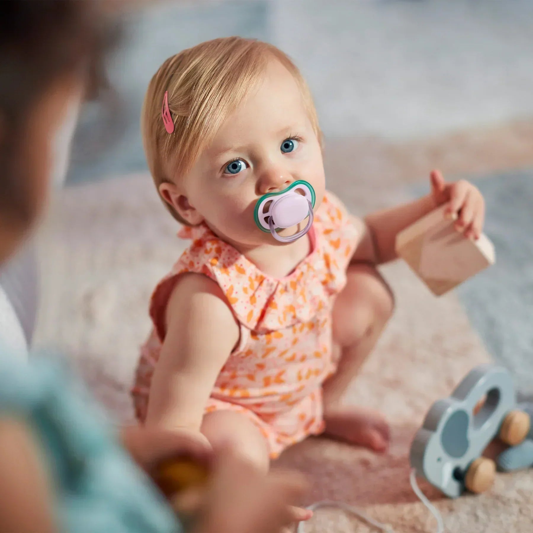 A girl self-soothes with a Philips Avent pacifier, designed for gentle comfort and healthy oral development.