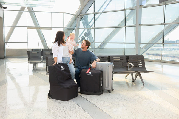 Parents traveling with their toddler at a Canadian airport, carrying a protective car seat travel bag for a smoother family trip.