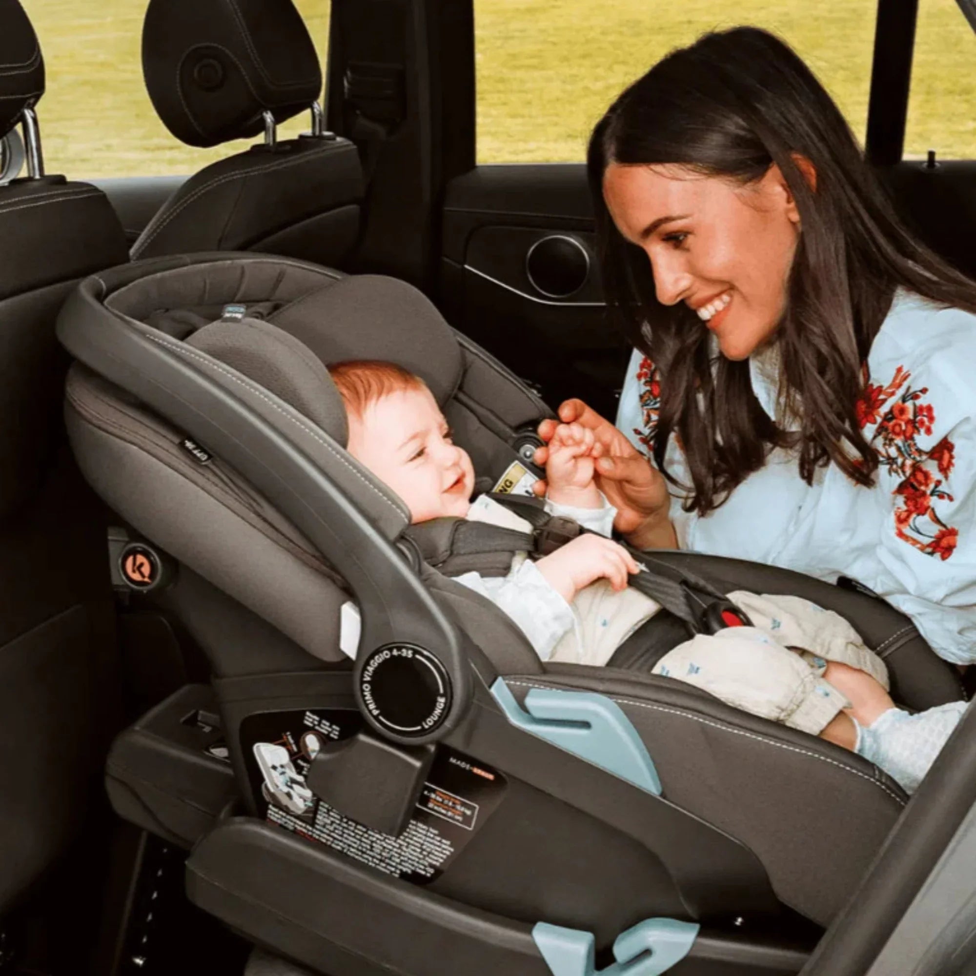 Mom with her baby sitting happily in the PEG Primo Viaggio 4-35 Nido car seat, safe and comfortable. 