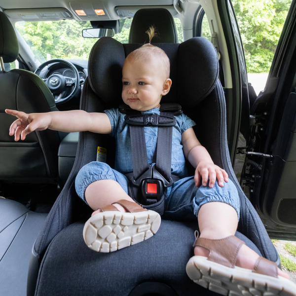 Happy baby sitting comfortably in the Clek Foonf car seat, showcasing its secure design, support, and everyday safety. 