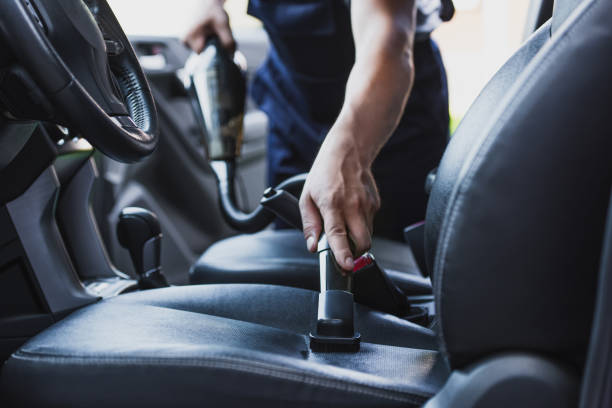 Car seat being cleaned with a vacuum.