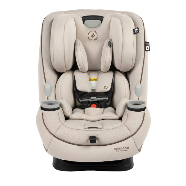 Maxi-Cosi convertible car seat in forward-facing mode with a caregiver fastening the five-point harness on a young child in a vehicle rear seat.