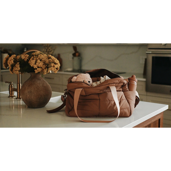MINIKA Diaper Bag displayed on a table, showcasing its stylish design, spacious storage, and everyday functionality.