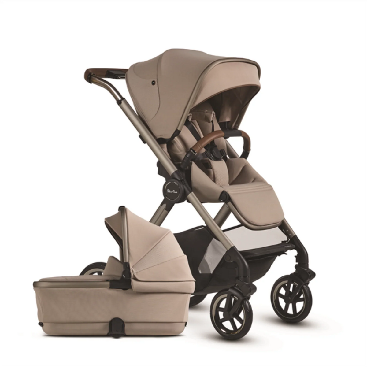 Sand-colored Silver Cross bassinet stroller with toddler seat and detachable carrycot, brown leather handlebar, angled view on a white background. 