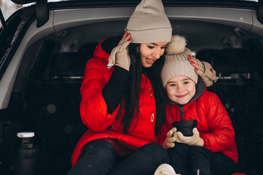 Mom and baby wearing warm clothes for a car trip in the winter.