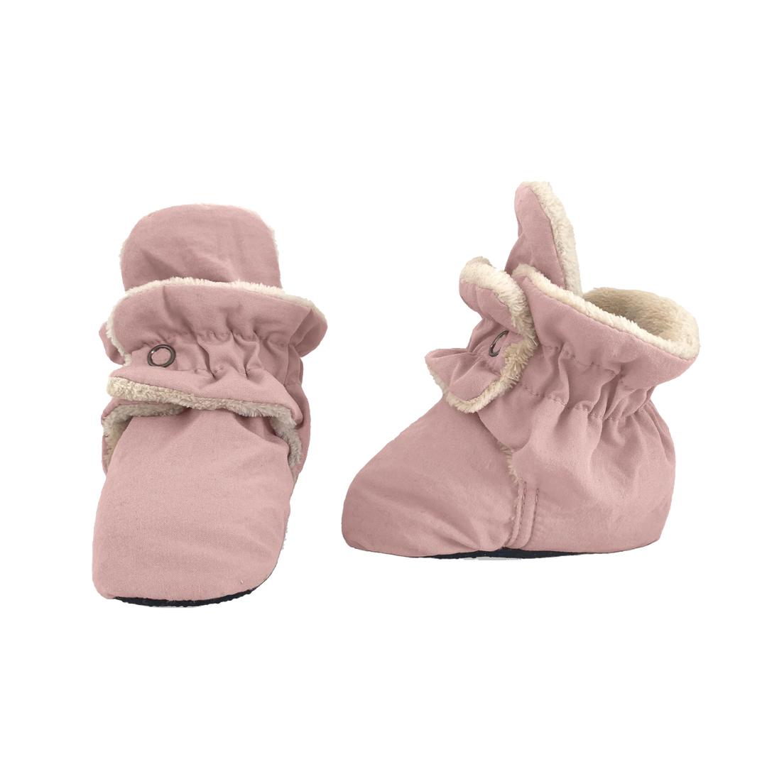 Pair of soft pink baby booties with elastic cuffs and cozy lining, designed to keep little feet warm and secure.