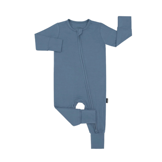 Soft bamboo footless baby sleeper in neutral beige with fold-over cuffs, laid flat to show stretchy fabric and cozy design.