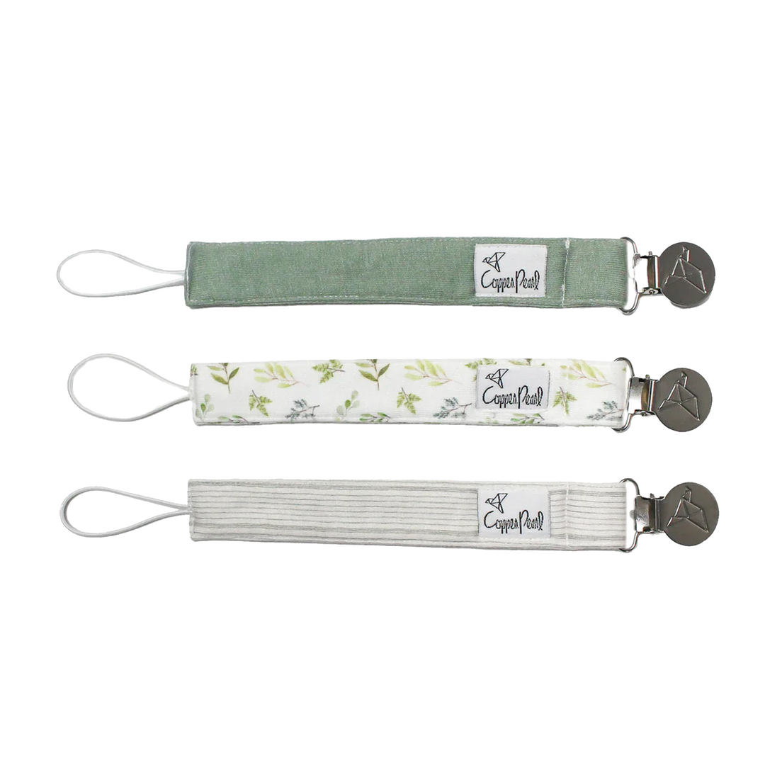 Set of three Suavinex pacifier clips in green, white with patterns, and grey.