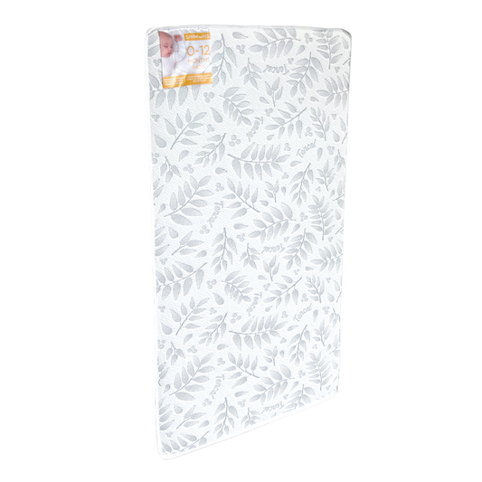 Sealy baby crib mattress with a white patterned cover for infant sleep support.