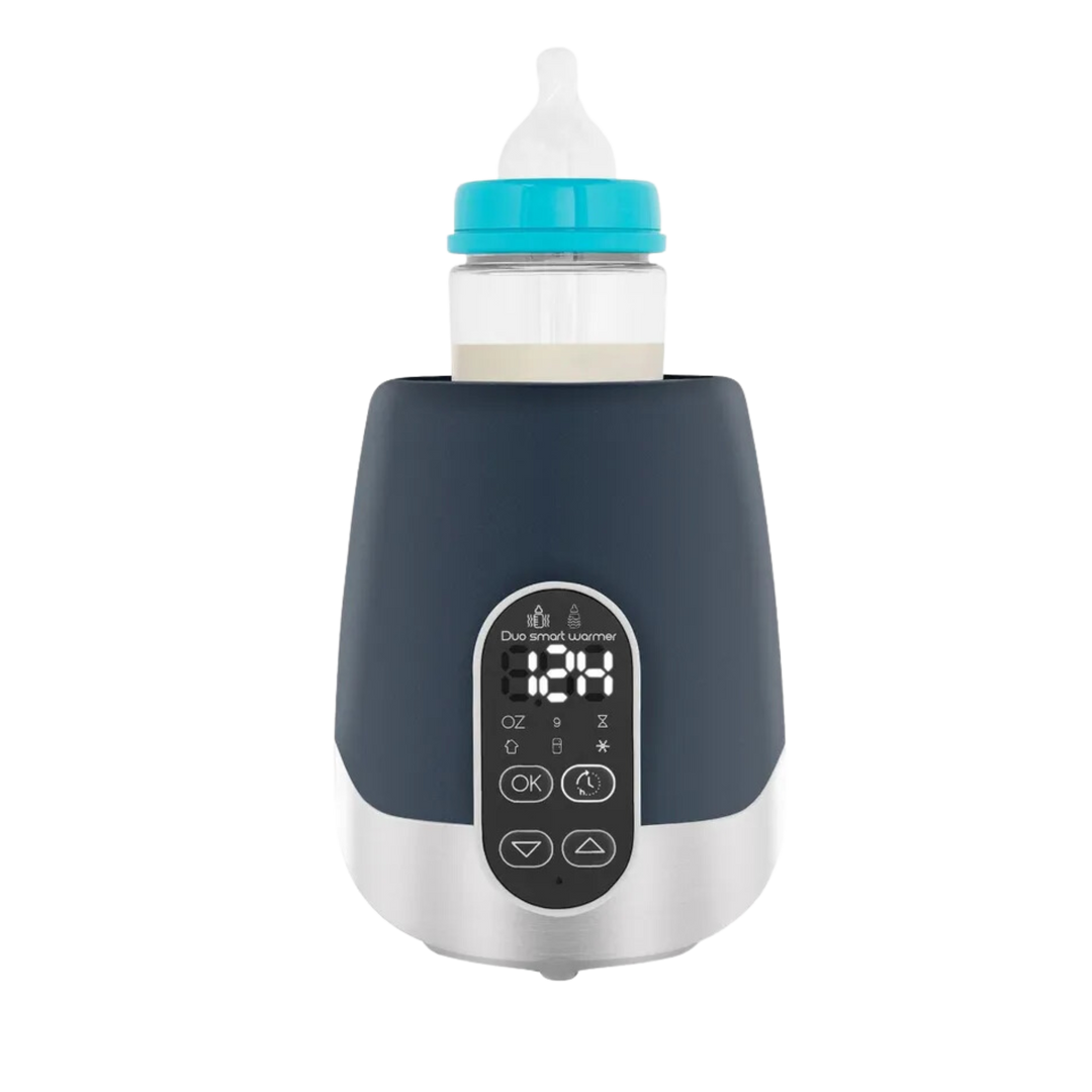 Black and silver digital baby bottle warmer with front display showing temperature, holding a baby bottle securely on top.