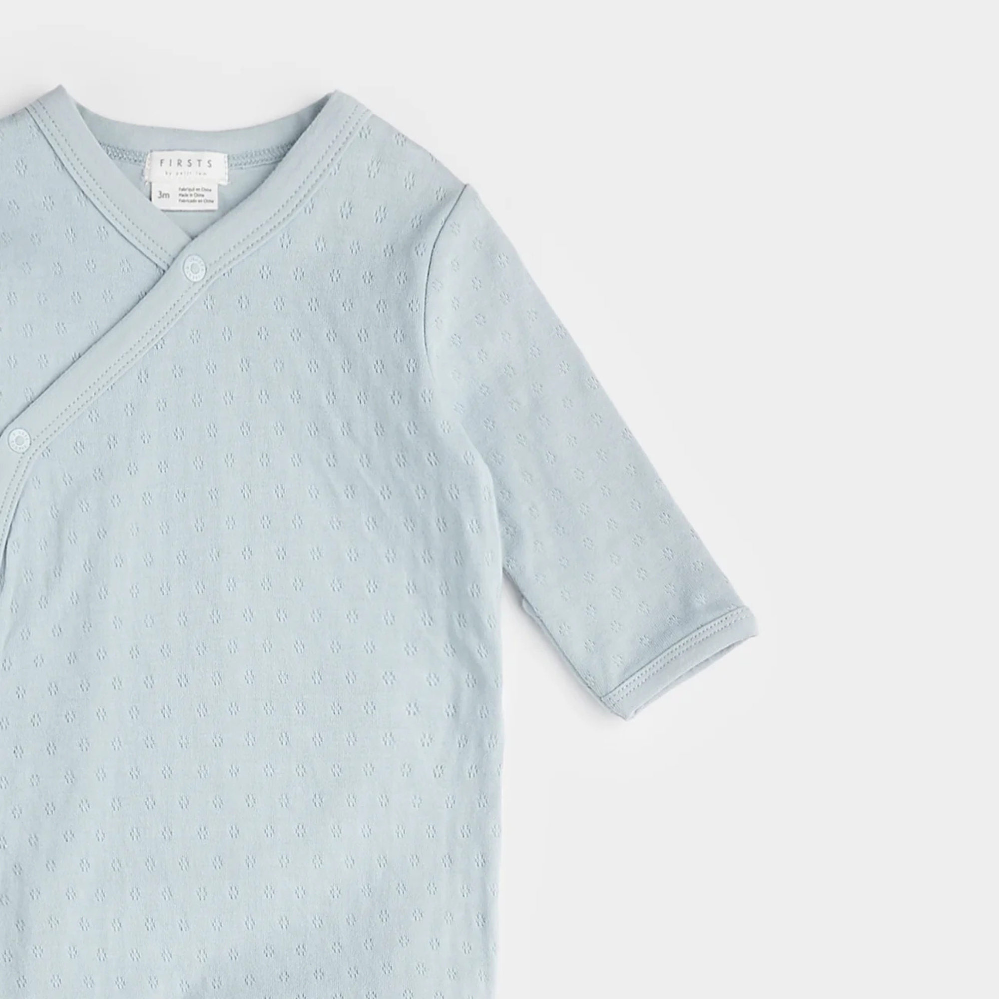 Grenouillère croisée en tricot pointelle bleu clair FIRSTS 