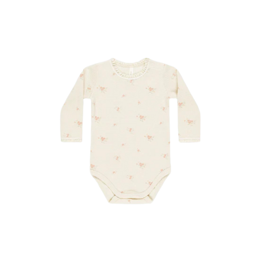 Cream-colored long-sleeve baby onesie with small pink floral print, made from soft cotton for cozy everyday wear.