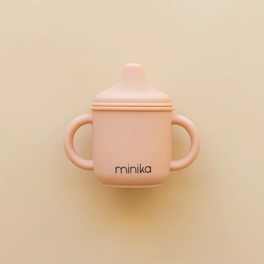 Pink Minika silicone sippy cup with dual handles for babies and toddlers.